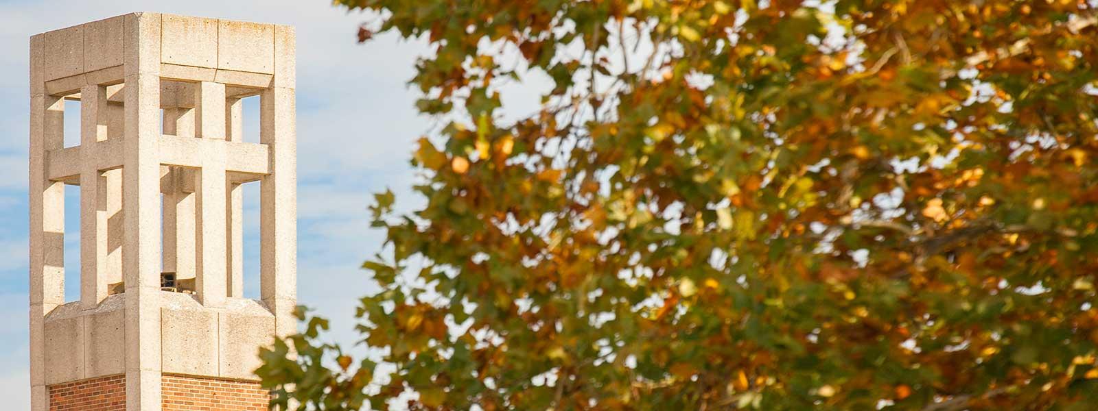 S-B-U bell tower framed by fall leaves